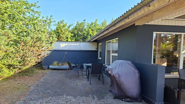 A patio with a barbecue grill, outdoor seating, and a view of the surrounding area. - 4 star holiday home in Sæby (Sæby)