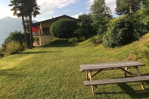 Un tavolo da picnic in una zona erbosa, con un edificio sullo sfondo.