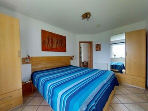 Ein Schlafzimmer mit einem großen Bett, einem Holzschrank und einem Bild an der Wand.