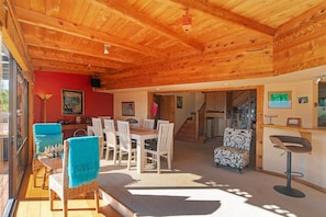 A wooden interior with a dining area, a bar, and a staircase. - Hilltop Ocean Views - Twin Outdoor Baths & Pool (Nelson)