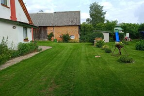 A well-maintained lawn with a house and a shed in the background. - Holiday apartment with 2 bedrooms (Mirow\/ Ortsteil Babke)