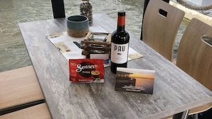Ein Tisch mit einer Pau-Wein-Flasche, einer Packung Senseo-Kaffeekapseln und einer Broschüre.