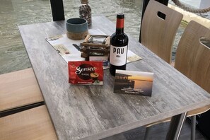 A table with a bottle of Pau wine, a pack of Senseo coffee pods, and a brochure. - myHolidayBoat Krimnicksee (Königs Wusterhausen)