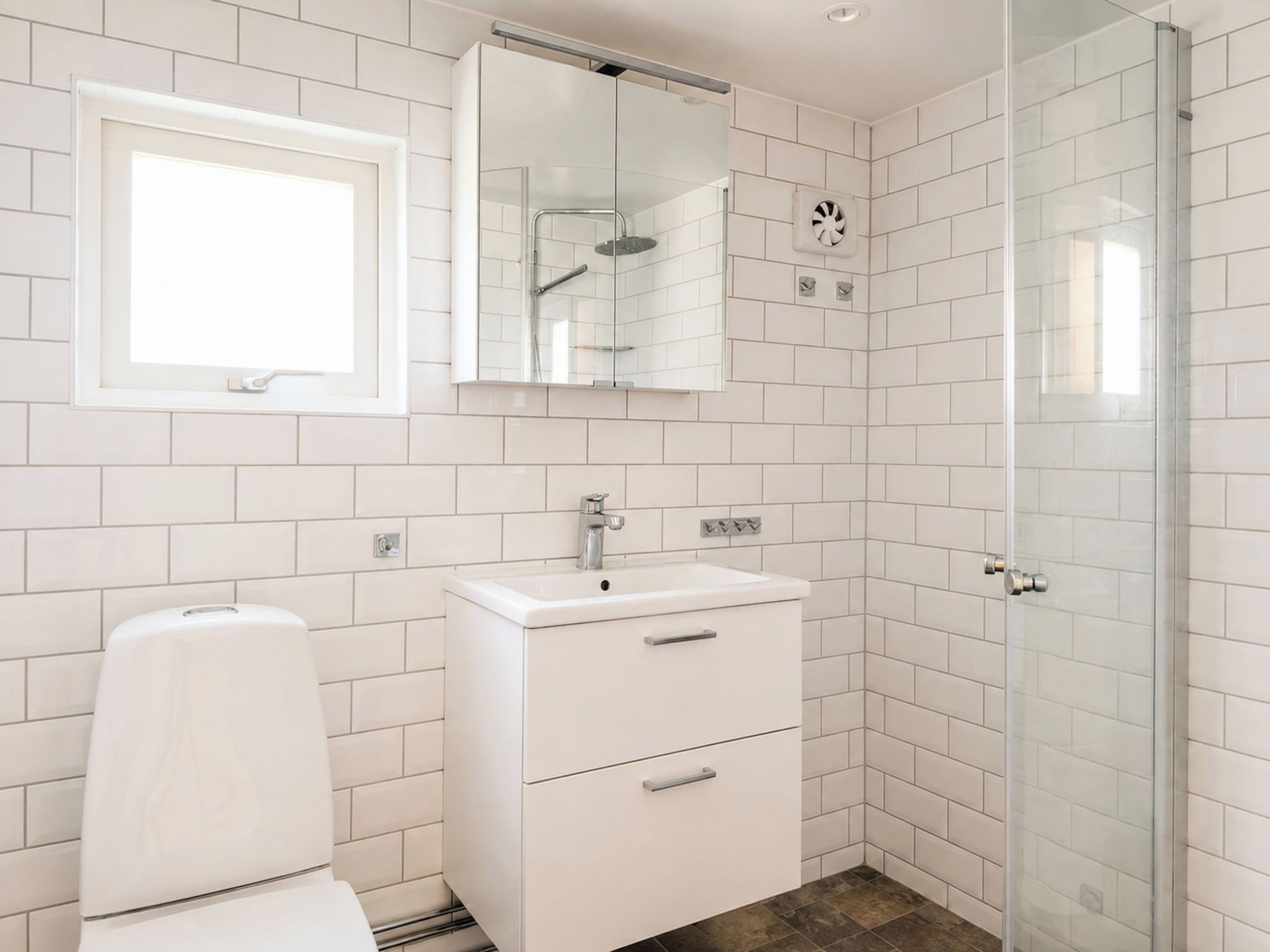 Une salle de bain moderne équipée de toilettes, d’un lavabo et d’une douche.