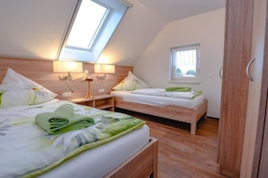 A bedroom with two beds, a skylight, and a window. - Holiday apartment with 2 bedrooms (Märkische Heide OT Biebersdorf)
