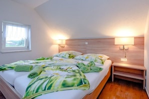 Une chambre à coucher avec un lit, deux lampes de chevet, une table de chevet et une fenêtre.