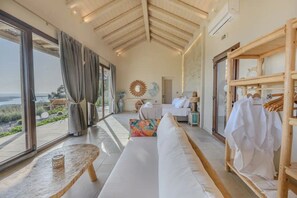 Een ruime kamer met een groot bed, een zithoek en een kledingrek.