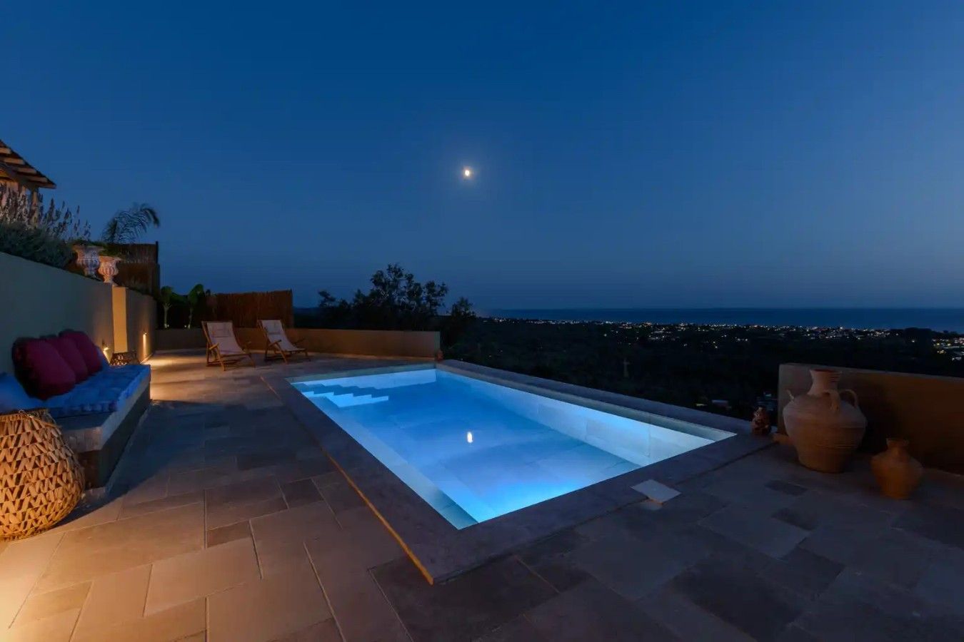 Ein Pool auf dem Dach mit Blick auf die Stadt im Abendlicht.