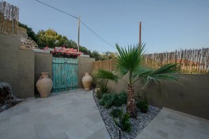 A courtyard with a tiled floor, a wooden gate, and two large vases. - AETHER - Romantic Private Pool Villa with Spectacular Ocean Views (Corfu)