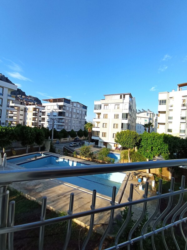 A residential area with multiple apartment buildings, a swimming pool, and a clear blue sky.