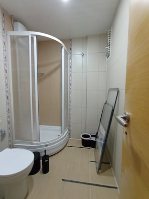 A bathroom with a shower enclosure, toilet, and a bidet.