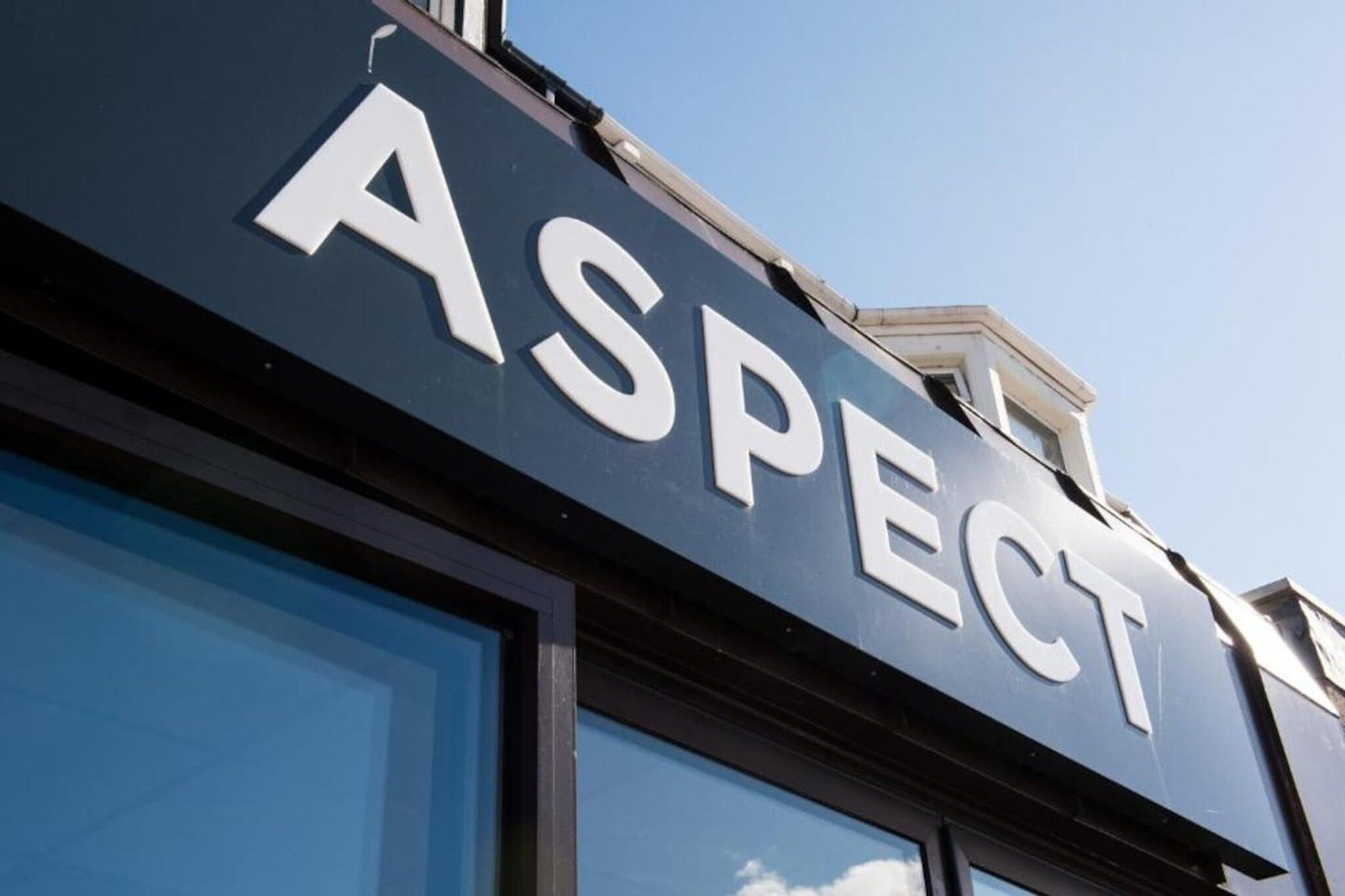 A building with a sign that reads 'ASPECT' on the facade.