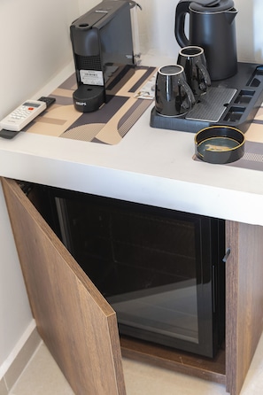 A kitchen area with a microwave, coffee maker, and a remote control on a countertop. - Verano suites- Premium suite, Luxury suites in the center of Rethymno (Rethymno)