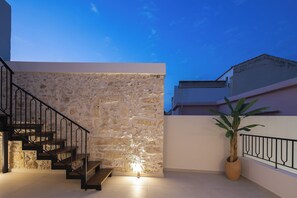 A staircase with a stone wall, a potted plant, and a railing. - Verano suites- Premium suite, Luxury suites in the center of Rethymno (Rethymno)