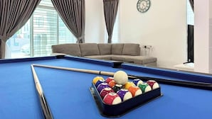 A pool table with a cue stick and balls, a sofa, and a clock on the wall. - Chapter 6 by Nature Home (Kuantan)