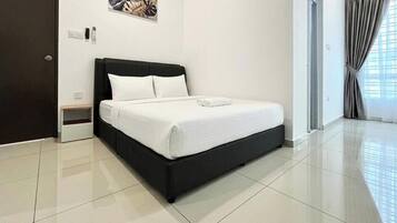 A modern bedroom with a black bed frame, white bedding, and a small bedside table.