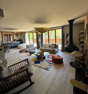 Een ruime woonkamer met een grote bank, een salontafel en een open haard.
