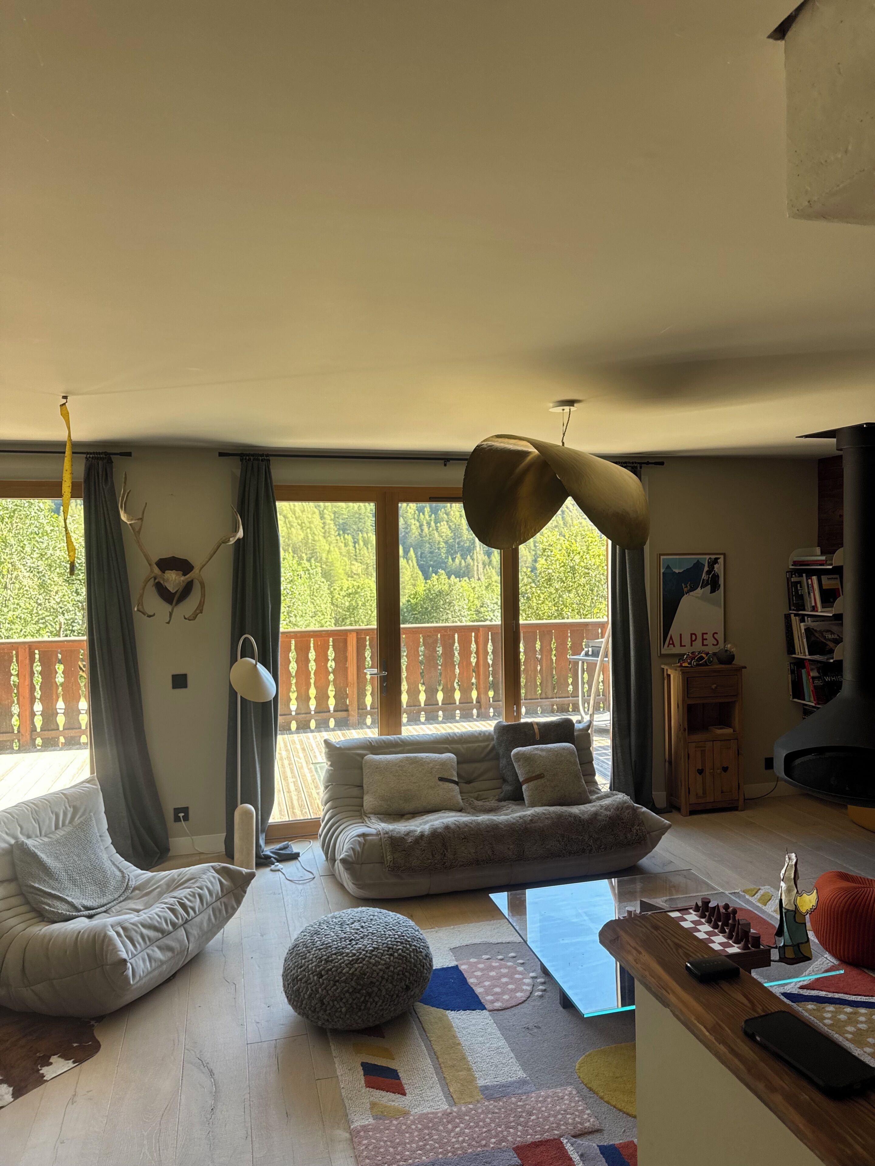 En rummelig opholdsstue med sofa, skammel og skakbræt.