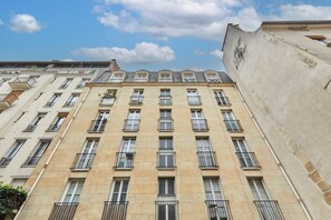 A multi-story building with a symmetrical facade, evenly spaced windows, and balconies. - Apartment Pantheon/saint Germain des Pres (Paris)