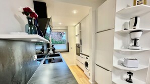 Eine moderne Küche mit einer Edelstahl-Arbeitsfläche, eingebauten Geräten und weißen Schränken.
