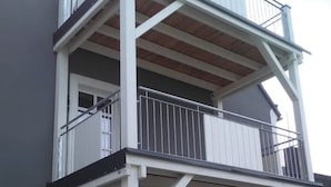 Ein mehrstöckiges Gebäude mit Balkonen und Geländern sowie einem Fenster.