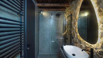 Une salle de bain avec une douche, un lavabo et un miroir.
