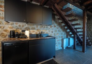 A kitchen with a dishwasher, coffee maker, and a refrigerator.