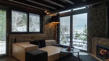Un salon chaleureux avec un canapé, un pouf et une cheminée.
