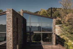 Un bâtiment moderne doté de grandes fenêtres en verre et d’une façade en pierre.