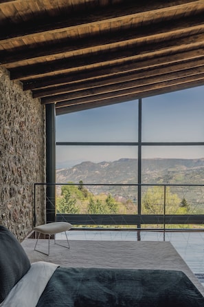 A bedroom with a large window overlooking a mountainous landscape. - Heartbeat Villa One, Heartbeat Mountain Escapes (Xylokastro - Evrostina)