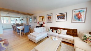 Un salon moderne avec un canapé, une table basse et un coin repas.