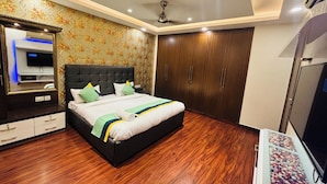 Un dormitorio con cama, armario y televisor.