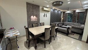 Un espacio moderno para vivir con comedor, sofá y un detalle decorativo en la pared.
