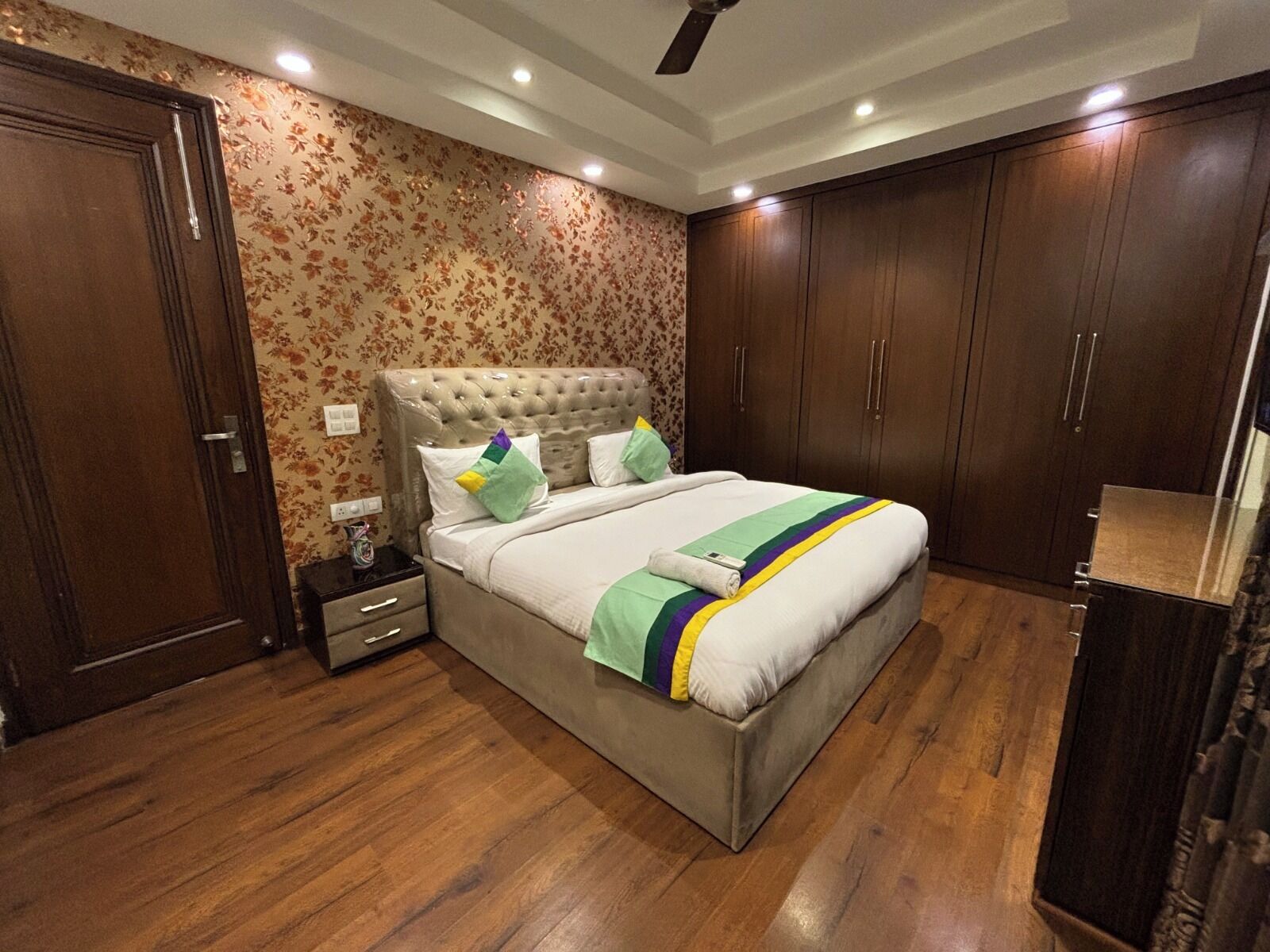 Une chambre à coucher avec un lit, une armoire en bois et une table de chevet.