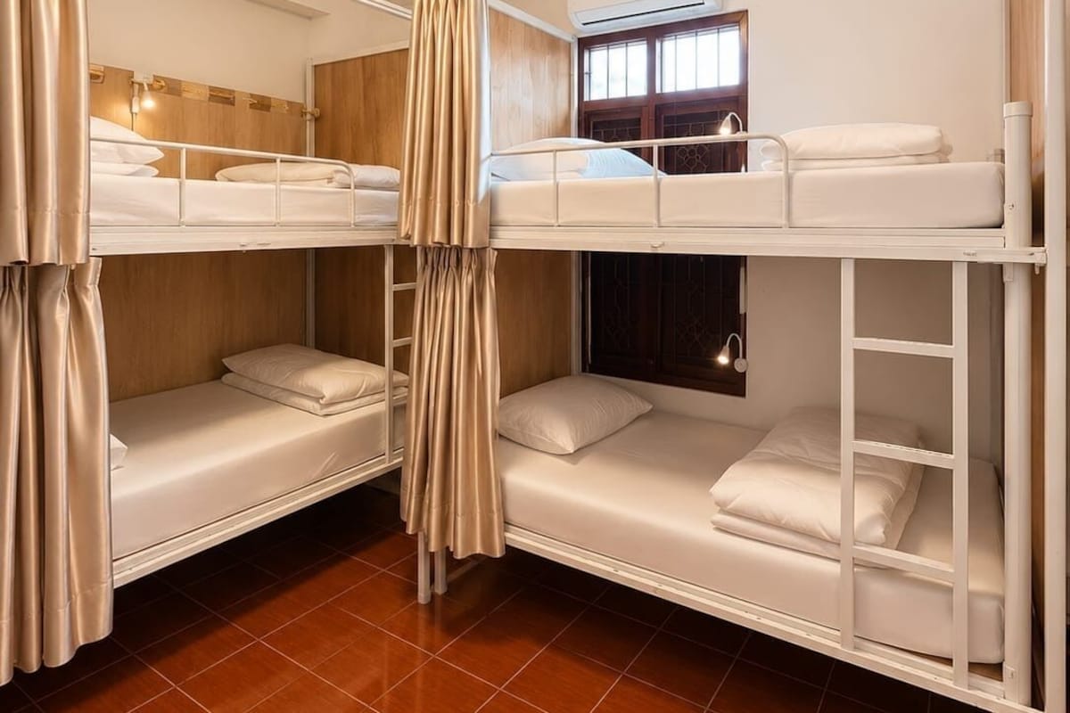 Habitación con literas, ventana, cortinas y luz de techo.
