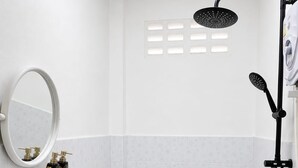 Un bany amb vàter, bidet, rentapel, dutxa i un mirall.
