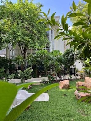 Um jardim bem cuidado, com diversas plantas e um caminho de pedra.