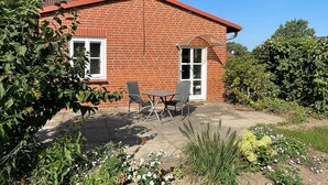A brick house with a patio, a table, and chairs. - Vrbo Property (Bohlsen)