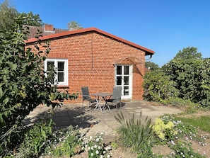 A brick house with a patio, a table, and chairs. - Vrbo Property (Bohlsen)