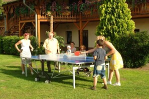 An outdoor table tennis setup with a table and paddles, surrounded by people. - Holiday apartment with 2 bedrooms (Märkische Heide OT Biebersdorf)