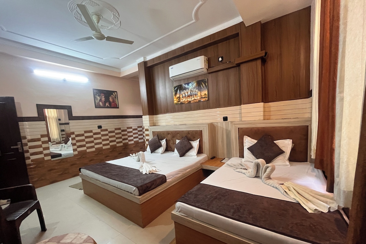 A hotel room with two beds, a ceiling fan, an air conditioning unit, and a checkered wall design.