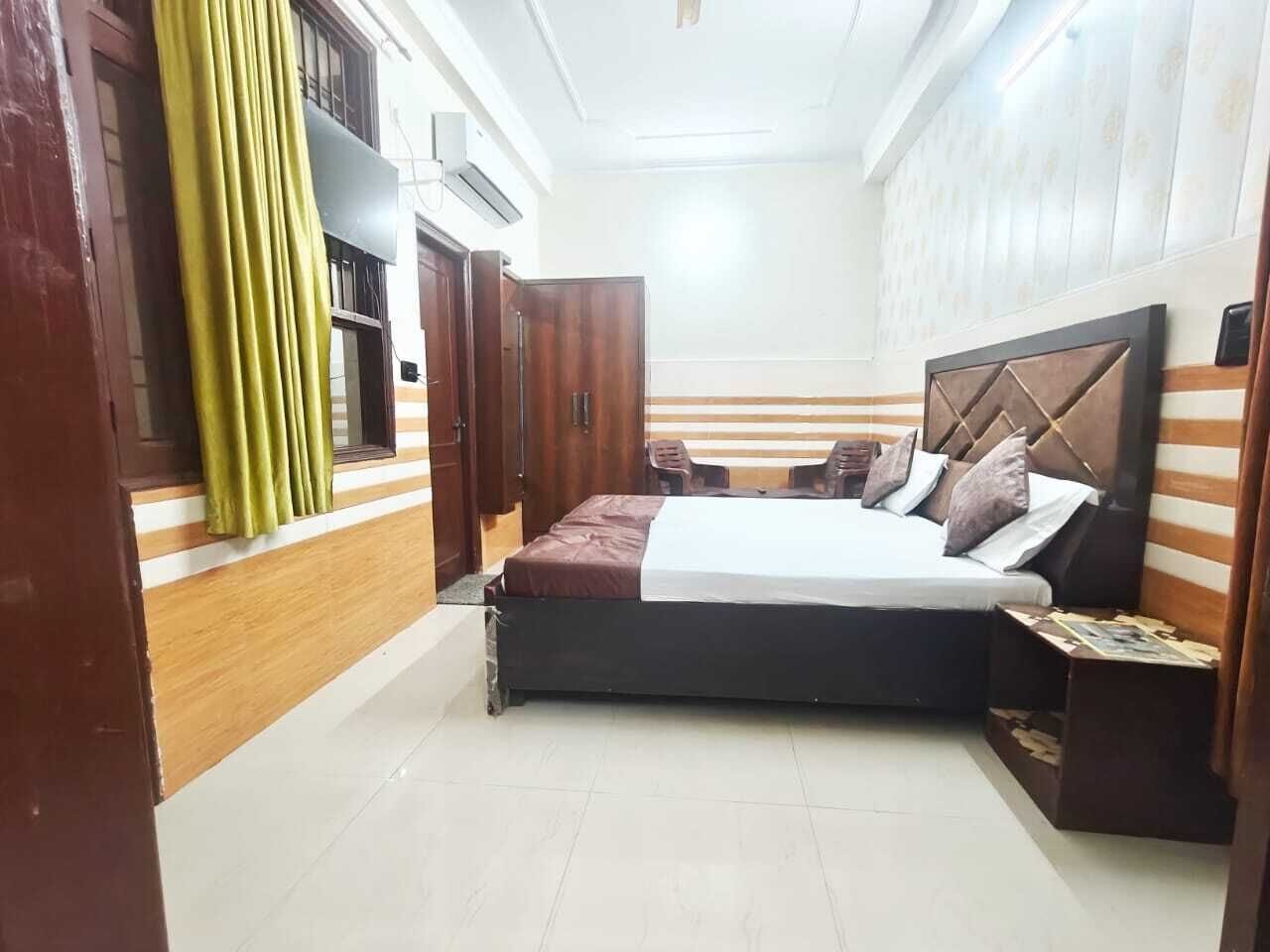 A bedroom with a bed, wooden wardrobe, and a nightstand.