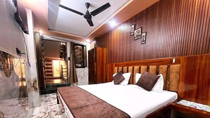 Una camera d'albergo con un letto, una ventola a soffitto, pannelli di legno e un pavimento in marmo.