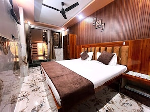 A hotel room with a bed, a ceiling fan, wooden paneling, and a marble floor. - VATS VILLA  (Vrindavan)