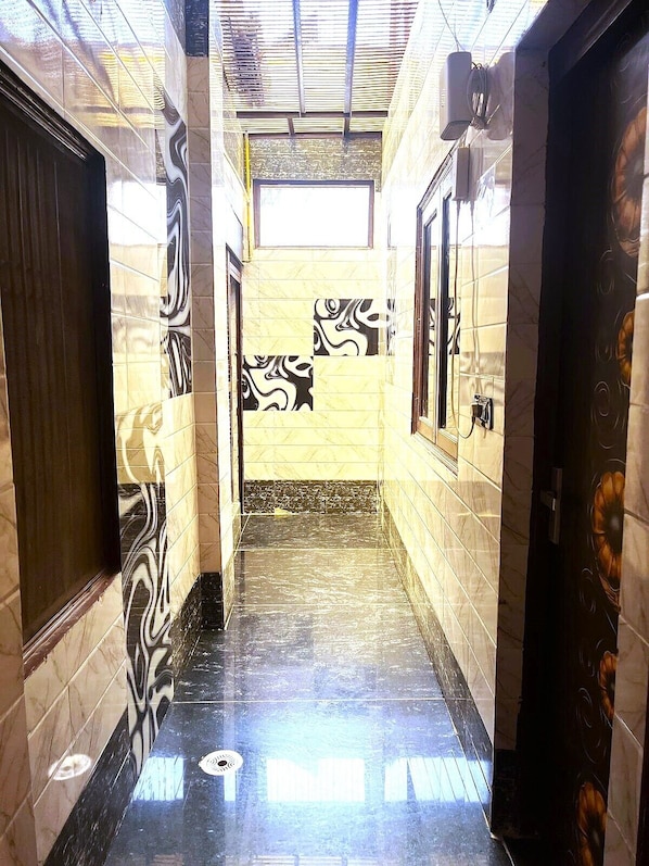 Un pasillo con paredes estampadas y piso brillante, que conduce a una puerta con diseño floral.