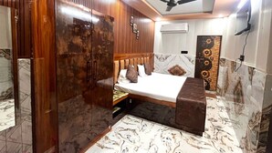 Una camera d'albergo con un letto, un armadio, una ventola a soffitto e pareti con decorazione a effetto marmo.