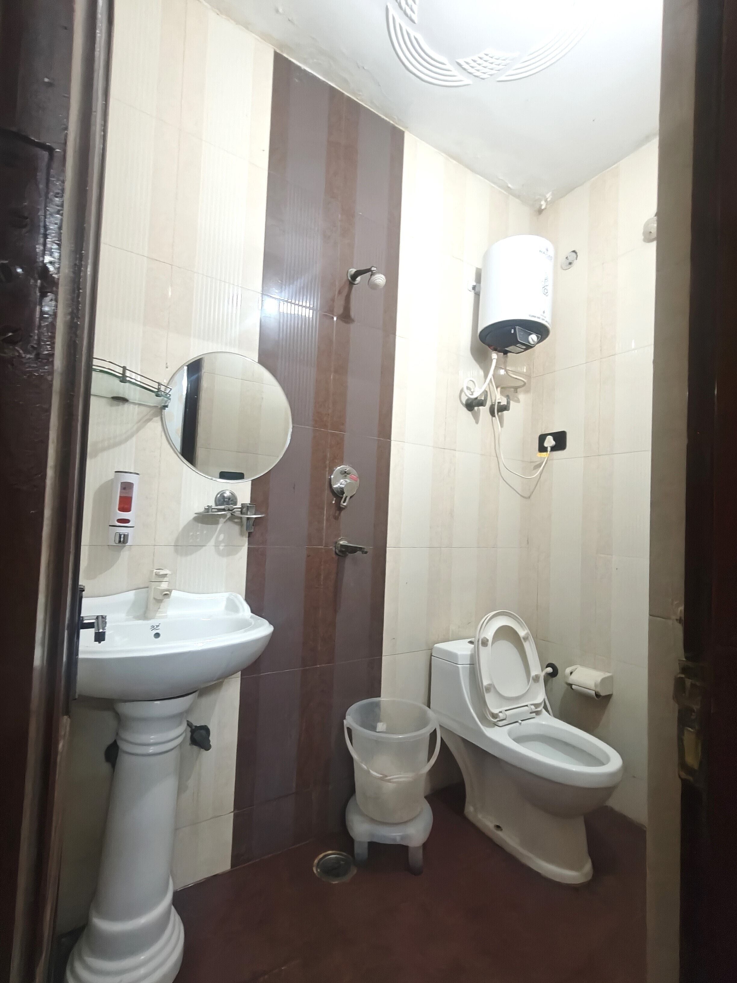 A bathroom with a pedestal sink, a toilet, a bidet, and a mirror.
