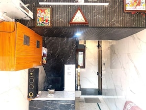 Un vestíbulo de hotel con un mostrador de recepción de madera, un reloj y una pared de mármol.