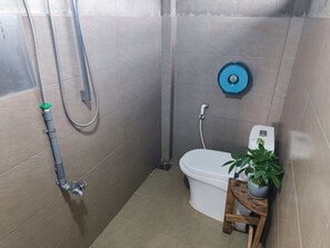 Ein kleines Badezimmer mit Toilette, Dusche und Waschbecken.