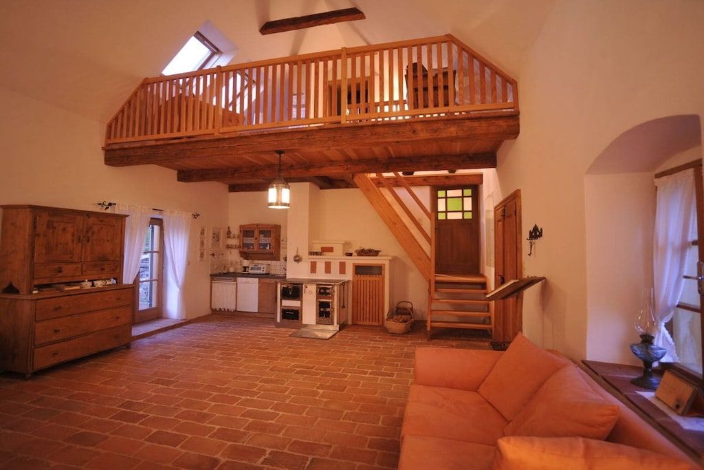 A spacious living area with a loft, a kitchen, and a staircase.